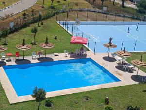 an overhead view of a swimming pool with chairs and umbrellas at Bel apprt a tanger beach in Tangier