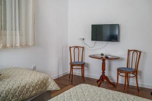 a bedroom with a table and two chairs and a tv at Kuća Petrovića in Aleksandrovac