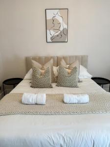 ein großes Bett mit zwei Kissen darauf in der Unterkunft Rickmansworth Lodge in Rickmansworth