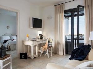 a bedroom with a desk and a bed with a television at Borgobianco Resort & Spa Polignano - MGallery Collection in Polignano a Mare