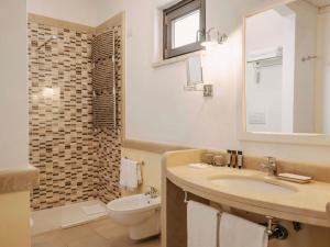 a bathroom with a sink and a toilet and a shower at Borgobianco Resort & Spa Polignano - MGallery Collection in Polignano a Mare