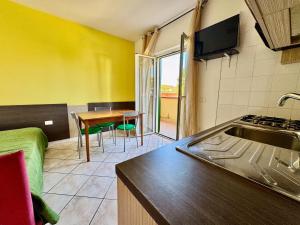 a kitchen with a sink and a table in a room at Conca Degli Dei in Paestum