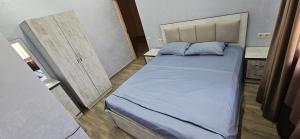 a small bedroom with a bed with blue pillows at OUR House in Vagharshapat