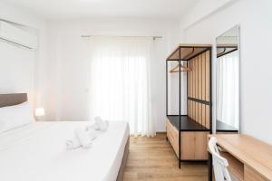 a bedroom with a white bed and a mirror at Green Almond Residential Complex in Orfánion +47 photos