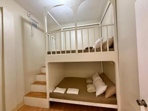 a white bunk bed in a small room at DM Guesthouse - Impasugong Bukidnon in Impasugong