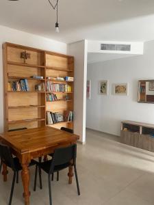 a dining room with a wooden table and chairs at MAISON ANZIO E ROSA in Ravenna