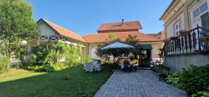 a house with a patio with chairs and an umbrella at Kuća Petrovića in Aleksandrovac