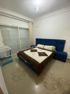 a bedroom with a blue bed and a blue couch at Marina Golf Asilah in Asilah +1 photo
