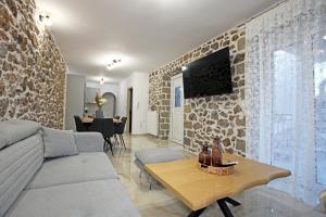 リトホロにあるElysian Stone Apartment IIのソファと壁掛けテレビのあるリビングルーム