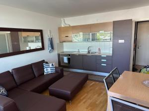 a living room with a couch and a kitchen at Marina View Apartment Izola in Izola