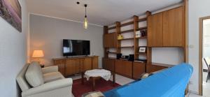 a living room with a blue couch and a tv at Vacation and business city apartment in Mönchengladbach +4 photos