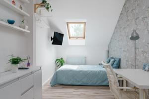 a bedroom with a bed and a desk in a room at Cozy Attic in Marki