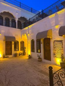 a courtyard of a white building with a balcony at Babilyon Otel in Urfa