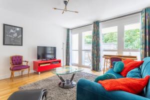 a living room with a blue couch and a tv at Jean Jaures - Appart Moderne avec Balcon & Parking in Chamalières