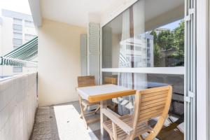 a small balcony with a table and chairs at Jean Jaures - Appart Moderne avec Balcon & Parking in Chamalières