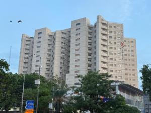 ein hohes Gebäude mit Bäumen davor in der Unterkunft DownTown Apartments Gulberg in Lahore