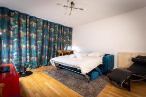 a bedroom with a bed and a chair in it at Jean Jaures - Appart Moderne avec Balcon & Parking in Chamalières