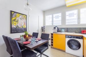 a kitchen with a table and a washing machine at Jean Jaures - Appart Moderne avec Balcon & Parking in Chamalières