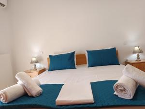 a bedroom with a large bed with blue pillows at Villa Eleni in Kypséli