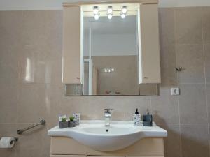 a bathroom with a white sink and a mirror at Villa Eleni in Kypséli +53 photos
