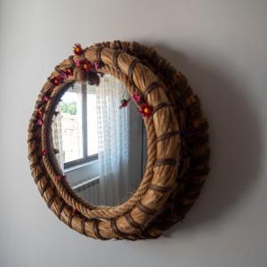 a wicker mirror on a wall with a window at Casa rural Regajo Lobos in San Bartolomé de Béjar +55 photos