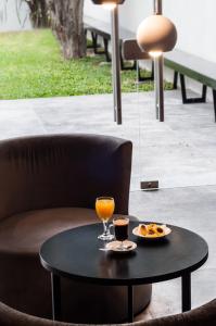 a table with a glass of orange juice and a plate of food at Temporal Suites in La Plata