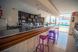 a bar with two purple stools in a restaurant at azuLine Hotel Mediterráneo in Santa Eularia des Riu