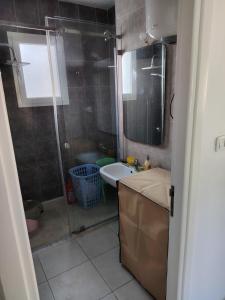 een badkamer met douche, wastafel en spiegel bij Dorra house in La Marsa