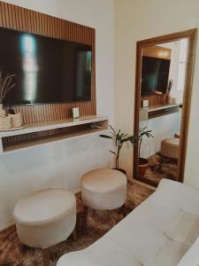a room with two stools and a large mirror at Wind Village Icaraizinho in Icaraí