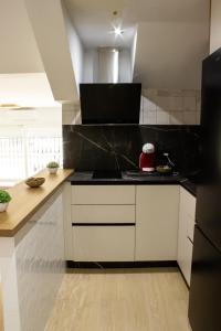 a kitchen with white cabinets and black counter tops at Gaviotas Playa in Almerimar