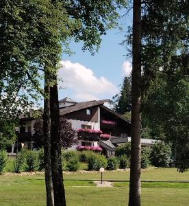 a building in the middle of a park with trees at Gasthof Hotel Schermer in Bad Häring