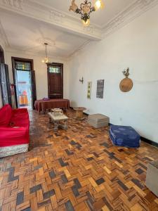 a living room with a red couch and a wooden floor at Caminito Salvador Hostel in Salvador