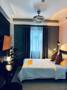 Un dormitorio con una cama grande y una ventana. en Smart Stay 2600 - Solo Condo Studio Units, en Baguio