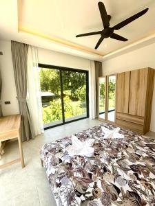 a bedroom with a large bed and a ceiling fan at Kohkohnut villa 3BR Villa with Private Pool in Bophut Near Fisherman in Amphoe Koh Samui +18 photos
