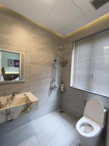 a bathroom with a toilet and a sink and a window at Villa ATH Nova Word Phan Thiết in Bình Tú