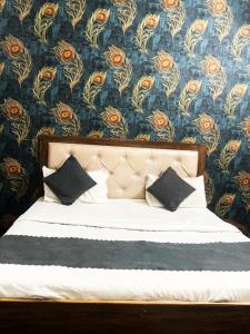 a bedroom with a bed with a floral wallpaper at EZ Stayz By Vilaasitaa Agra in Agra
