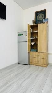 a kitchen with a refrigerator and a wooden cabinet at Deutsch Hostel Osh in Osh