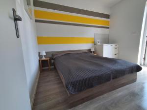 a bedroom with a bed with a striped wall at Ludna 27 in Niechorze +58 photos