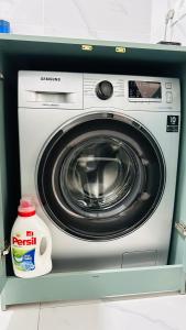 a washing machine with a bottle of detergent next to it at Deutsch Hostel Osh in Osh