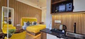 a hotel room with a bed and a television at Stayinn Suites in Bhopal