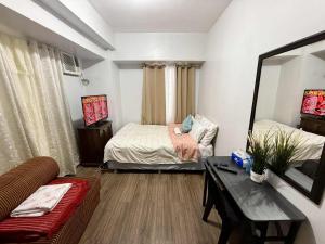 a living room with two beds and a couch at LaVerti 1BR Affordable staycation groups family in Manila +13 photos