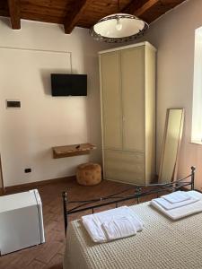 a bedroom with a bed and a cabinet and a television at Affittacamere Carnevali MJ in Loreto