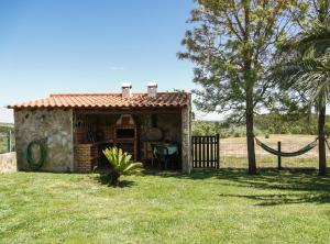 a small house in a field with a fence at Monte dos Touris in Santiago do Cacém