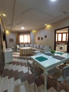 a living room with a table and a couch at Passo Nador 3 chambres in Nador