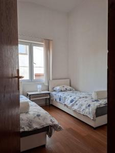 two beds in a room with a window at Apartman Maša Bileća in Bileća