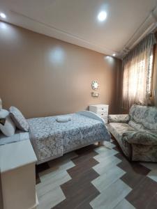 a bedroom with a bed and a couch at Passo Nador 3 chambres in Nador
