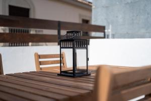 a black lantern sitting on top of a wooden table at Casa 'Esquina Cortijos' en el Centro de Úbeda in Úbeda