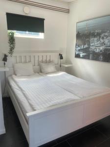 una camera bianca con un grande letto bianco di Kungsgatan 36 a Borgholm Altre 2 foto