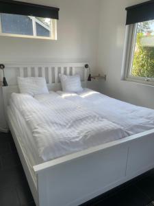 un grande letto bianco in una stanza con una finestra di Kungsgatan 36 a Borgholm