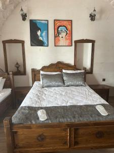 a bedroom with a large wooden bed with two mirrors at Babilyon Otel in Urfa